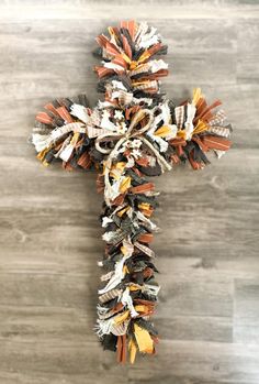 a crucifix made out of newspaper strips on a wooden floor with wood planks in the background