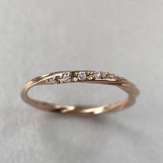 a gold wedding band with five diamonds