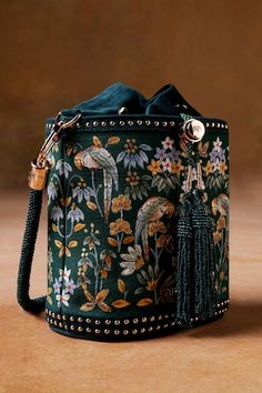 Starling green cylindrical shaped bucket bag with Pichhwai, bird, floral hand painted motifs, zari thread embroidery and metallic stud embellishment. Comes with 2 detachable handles. - Aza Fashions Hand Painted Bags Handbags, Handbags Unique, Painted Leather Bag, Hand Painted Purses, Painted Handbag, Handpainted Bags, Anita Dongre, Ethnic Bag, Vintage Evening Bags