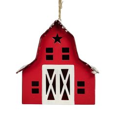 a red barn shaped ornament hanging from a rope