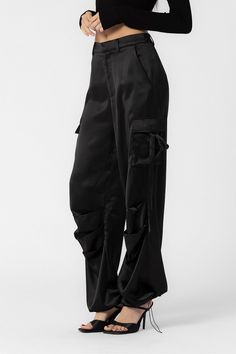 These black Elly cargo pants feature cargo pockets on the side and an adjustable drawstring on the ankle perfect for customizing your fit as needed. Loose fitting 100% polyester SALE ITEMS ARE FINAL SALE Return Policy SALE ITEMS ARE FINAL SALE. Feel free to email us at info@shopluxxeapparel.com or DM us with any questions regarding fit, styling, or our return policy in general. To read more into our return policy please click here. Black Satin Cargo Pants, Satin Cargo Pants, Cargo Pants Outfit Women, Cargo Pants Outfit, Black Cargo Pants, Black Cargo, Pants Outfit, Black Media, Wearing Black