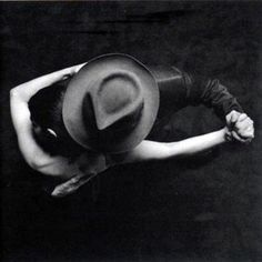 black and white photograph of a woman wearing a cowboy hat with her hands on her hips