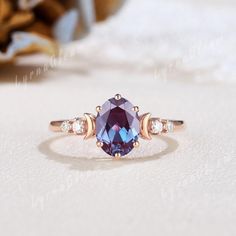 a ring with an oval shaped blue stone surrounded by three smaller round diamonds on top