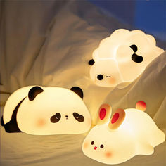 three panda lamps sitting next to each other on a bed