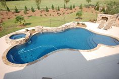 an outdoor swimming pool surrounded by landscaping