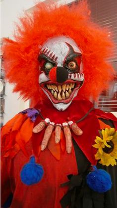 a clown with orange hair and red makeup