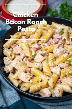 chicken bacon ranch pasta in a black bowl on a blue table cloth with parsley