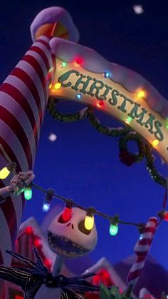 a christmas sign with lights on it and a jack - o'- lantern in the foreground