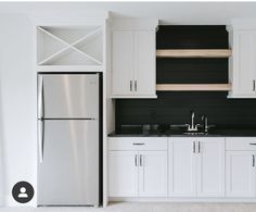 a kitchen with white cabinets and black counter tops