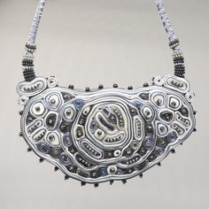 This silver statement necklace is the biggest and most extravagant textile necklace. A collier femme is made for a special occasion. Abstract shape filled with small circles and ribbon layers creates a new look and exclusive fiber artwork piece. At least the graphite grey and pearl color beads as a final touch were added. I created this original statement necklace using my beloved grey, silver, and white colors which add a waft of elegance and chick. This fiber art jewelry piece is a perfect gif Elegant Handmade Metal Bib Necklaces, Elegant Handmade Metal Bib Necklace, Handmade Silver Necklace In Wearable Art Style, Handmade Silver Beaded Necklaces For Party, Silver Bib Necklace Choker For Evening, Unique Silver Beads Necklace, Handmade Metal Bib Necklace For Party, Unique Handmade Bib Necklace, Handmade Silver Beaded Necklaces For Evening