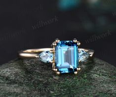 a blue topazte and diamond ring sits on a rock