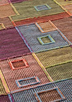 a multicolored rug with squares and rectangles on the bottom one side