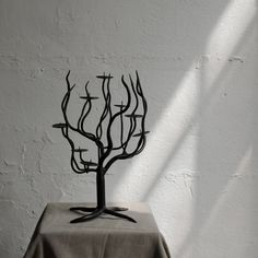 a metal tree sculpture sitting on top of a table