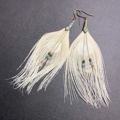 White feather earrings offer a stunning piece of bohemian statement jewelry, perfect for a bride seeking spiritual guidance on her special day. These long statement earrings make a meaningful gift for women, ideal for a wedding or other memorable occasions. You may request smaller or larger feathers in the notes section of your order. 🪶 𝗠𝗔𝗧𝗘𝗥𝗜𝗔𝗟𝗦 + 𝗗𝗜𝗠𝗘𝗡𝗦𝗜𝗢𝗡𝗦 ❯  Earrings measure 3-1/2 to 4 inches long ❯  Swarovski Crystal, Hematite, Brass French Earring Wire 🪶 𝗦𝗧𝗢𝗡𝗘 + 𝗘𝗟𝗘𝗠𝗘𝗡𝗧 𝗘𝗡𝗘𝗥𝗚𝗬 ❯  FEATHERS symbolize our divine guidance ❯  HEMATITE is known to foster peace and stability 🪶 𝗣𝗘𝗥𝗦𝗢𝗡𝗔𝗟𝗜𝗭𝗔𝗧𝗜𝗢𝗡 + 𝗚𝗜𝗙𝗧 𝗦𝗘𝗧 𝗦𝗨𝗚𝗚𝗘𝗦𝗧𝗜𝗢𝗡𝗦 ❯  Toggle Bracelet (photo 8) -- lorenlavinedesigns.etsy.com/listing/1052937100 ♻️  𝗘𝗖𝗢-𝗙𝗥𝗜𝗘𝗡𝗗𝗟? White Feather Dangle Earrings, Bohemian White Tassel Earrings For Pierced Ears, Adjustable White Feather Jewelry, Bohemian White Chandelier Earrings For Festivals, Bohemian Tassel Dangle Earrings For Wedding, Bohemian Feather Earrings For Festivals, Elegant Adjustable Feather Earrings, Elegant Adjustable Tassel Earrings For Festivals, Bohemian White Chandelier Earrings