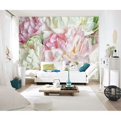 a living room with white furniture and large floral wall mural on the wall behind it