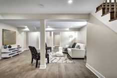 a living room filled with furniture and a staircase leading up to the second floor area