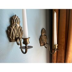 two candle holders are attached to the wall