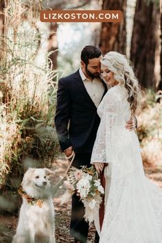 a bride and groom standing in the woods with their dog