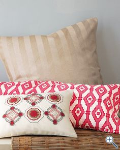 two decorative pillows on a wooden bench