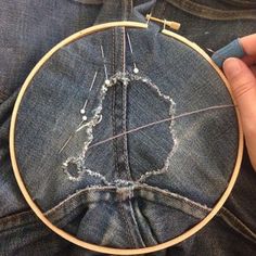 someone is stitching something in the back pocket of their jean pants with a needle