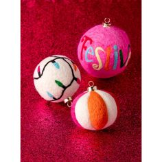 three ornaments with the word smile on them are sitting on a red carpeted surface