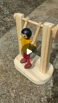 a wooden toy standing on top of a table next to a piece of wood with a man in it