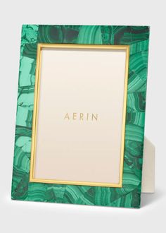 a green and gold frame with the word aerin on it in front of a white background