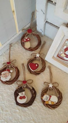 six christmas ornaments hanging from twine on the floor