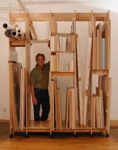 a man standing in the doorway of a book shelf filled with books and papers on wheels