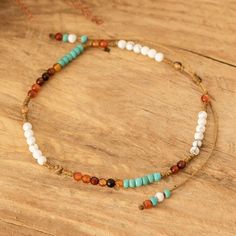 a multicolored beaded necklace on a wooden surface