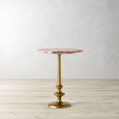 a gold pedestal with a pink marble top