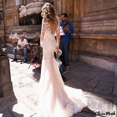 a woman in a wedding dress standing on the street