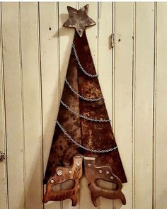 a metal christmas tree hanging on the side of a white wooden door with chains around it