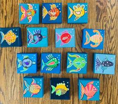 colorful fish are painted on small square tiles in the shape of magnets that look like they have been placed together