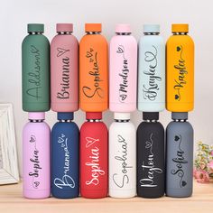 six different colored water bottles with names on them