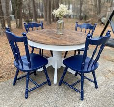 a white table with blue chairs around it