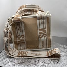 This Steve Madden Bag In Tan Has A 2” Adjustable, Removable Strap. The Strap Has Sm And Steve Madden Printed On Both Sides. The Shoulder Drop Is Currently 24.5” But Can Be Adjusted As Needed. There Is An Attached Pouch That Can Be Removed. Shiny, Sturdy Gold Hardware Can Be Seen Throughout. Double Handle Straps Are Also Available. These Are Not Removable. This Bag Closes Magnetic Style At The Top. The Inside Has One Zippered Pocket And Two Slip Pockets. The Height Of This Bag Is 7.5”, Width Is 9”, Depth Is 4.5”. This Bad Is In Excellent Condition And Comes From A Smoke Free Environment. There Is One Tiny Imperfection. A Small Dot Can Be Found On The Attached Pouch. Please Check Ph Steve Madden Backpack, Steve Madden Wallet, Neon Bag, Steve Madden Purse, Steve Madden Handbags, Summer Purses, Convertible Crossbody Bag, Quilted Crossbody Bag, Steve Madden Bags