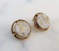 "The simple 14k yellow gold bezel-settings showcase the round gold-in-quartz stones within these antique 1910s earrings. Black enamel rings and textured spheres frame the stones nicely. Gold-Bearing Quartz is one of the world's rarest forms of natural gold. It is found underground by hard rock miners in only a few locations in the world. The natural veins of pure gold were formed in quartz by hydrothermal pressure deep within the earth millions of years ago. The flat polished gems are of white t Luxury Round Cabochon Clip-on Earrings, Formal Oval Earrings With Bezel Setting, Formal Oval Bezel Set Earrings, Formal Yellow Gold Gemstone Clip-on Earrings, Evening Yellow Gold Cabochon Jewelry, Luxury Gold Earrings With Bezel Setting, Formal Brass Jewelry With Cabochon, Formal Brass Cabochon Jewelry, Yellow Gold Cabochon Round Earrings