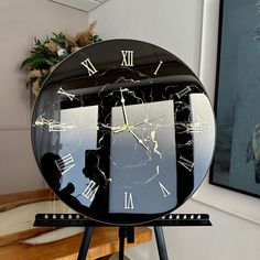 a black and white clock with roman numerals on it