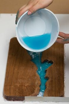 someone is pouring blue liquid into a bowl