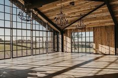 an empty room with large windows and chandelier