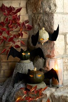 halloween decorations with bats and pumpkins hanging from the ceiling in front of a brick wall