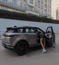 a woman leaning into the open door of a car