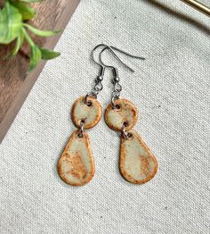 Super cute everyday dangle earrings! Handmade from stoneware clay & glazed in a shino glaze creating a burnt orange color around the edges. This pair of earrings are finished with a stainless steel hook, are lightweight, & hypoallergenic for all day comfort! -Length: 5cm (approximate)  -Hypoallergenic: all earrings findings or necklace chains are made with nickel-free metals such as stainless steel, gold-plated or silver-plated -Comfort: the jewelry findings are made with hypoallergenic materials making them comfortable for sensitive ears & everyday, all-day wear. In addition, the clay is rolled into a thin slab before being cut making them nice & lightweight  -Durability: the high temperatures reached in the kiln-firing process increases durability & strength or the clay however they shou Unique Everyday Clay Jewelry, Bohemian Polymer Clay Earrings For Everyday, Everyday Bohemian Polymer Clay Earrings, Nickel-free Clay Jewelry For Everyday Wear, Bohemian Dangle Clay Jewelry, Hand Painted Bohemian Earrings For Everyday, Everyday Hand Painted Dangle Jewelry, Earthy Everyday Dangle Earrings, Hand Painted Clay Earrings For Everyday Wear