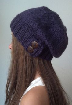 a woman with long hair wearing a knitted beanie and buttoned up hat