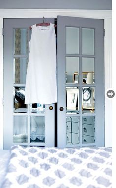 a white dress hanging on a clothesline in front of a bedroom door