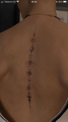 the back of a woman's neck with an intricate tattoo on her left shoulder