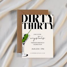 a birthday party card with a martini glass and green olives on the top, next to a brown envelope