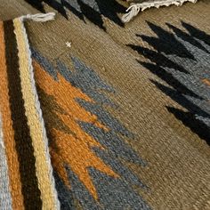 an area rug with different colors and patterns on it, including oranges, browns and blue