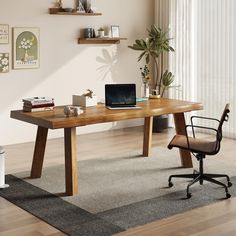 a wooden desk with a laptop computer on top of it next to a chair and potted plant